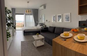 a living room with a couch and a table at Apartament Elizabeth Caesar Blue in Trikomo