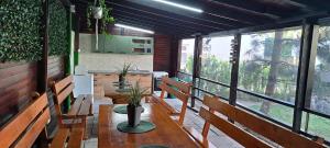 a restaurant with wooden benches and a table with plants at VILA TAMI in Costinesti