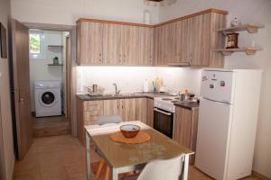 a kitchen with a table and a white refrigerator at The Graffiti House in GlifÃ¡dha