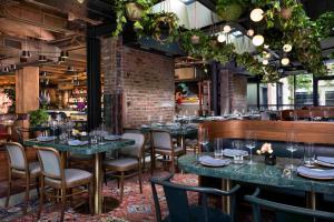 a restaurant with tables and chairs and a brick wall at Populus Seattle in Seattle