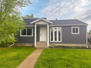 una casa grigia con una porta bianca e l'erba di Perfect for West End Shopping a Billings