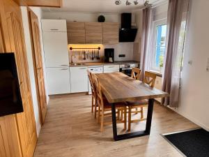 a kitchen with a wooden table and chairs in a room at Ferienhaus mit eigenem Garten 2 SZ 2 Bäder 70QM in Joachimsthal