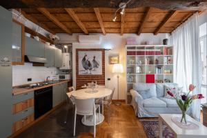 a kitchen and living room with a table and a couch at Italian Experience-Dafne Suite in Pavia