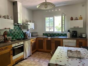 a kitchen with wooden cabinets and a table in it at Maison de vacances Bazas in Lignan-de-Bazas +20 photos