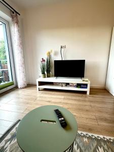 a living room with a table and a television at Apartament Nad Stawem in Wadowice +4 photos
