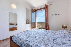 a bedroom with a bed and a large window at GuestHost - Bedà House in Porto Carollo
