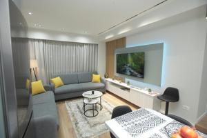 a living room with a couch and a tv at Dream House Enia 4 in Shkodër
