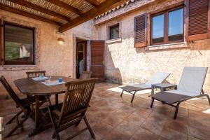 an outdoor patio with a wooden table and chairs at GuestHost - Bedà House in Porto Carollo