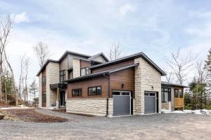 Lake of BaysShooting Star Lodge BBQ Firepit SPA Relax的前面有车库的房子