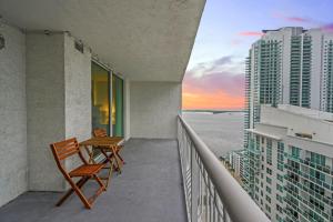 a balcony with two chairs and a table on a building at Skyline and Bay Glimpse 1BR Brickell Retreat in Miami