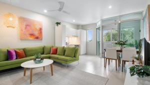 a living room with a green couch and a table at Bayside at 201 Lake Street in Cairns North