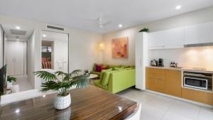 a kitchen and a living room with a green couch at Bayside at 201 Lake Street in Cairns North