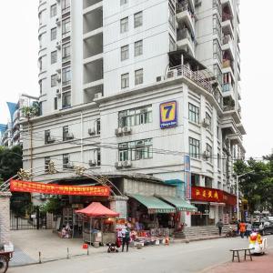 un grand bâtiment blanc avec un marché devant lui dans l'établissement 7Days Inn Guangzhou Meihuayuan Metro Station, à Canton