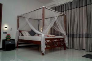 a bed with a canopy in a room at Elegance Lake View in Habaraduwa Central