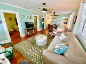a living room with a couch and a tv at Oceans 11 Steps from the Ocean on Quiet Beach in Saint Augustine Beach