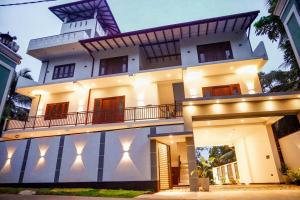 a large white building with lights on it at Elegance Lake View in Habaraduwa Central