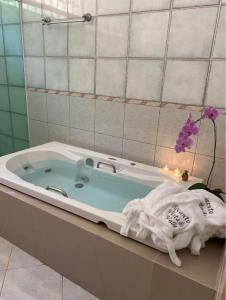 Una bañera con una toalla y una flor en un baño. en Recanto Vista do Valle, en Mairiporã