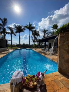 Una piscina con una mesa de comida al lado. en Recanto Vista do Valle, en Mairiporã