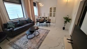 a living room with a couch and a table at Deichliebe 2 - Modern, Zentral & Familienfreundlich - Inklusive privater Stellplatz im Parkhaus 2min zu Fuß entfernt in Bremerhaven