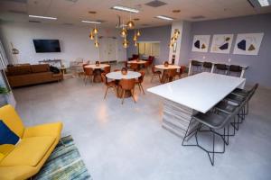 ein großer Raum mit Tischen und Stühlen und einer Couch in der Unterkunft Lovely 2BR in the Heart of Brickell Free Parking in Miami