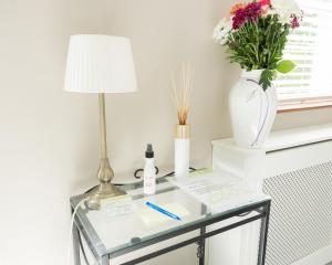 a glass table with a lamp and flowers on it at Brielle House in Mountmellick