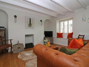 Una sala de estar con un sofá y una chimenea. en Trelan, en St Austell