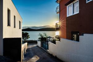 a view of the water from a house with the sunset at Sydney Apartment in Bilice