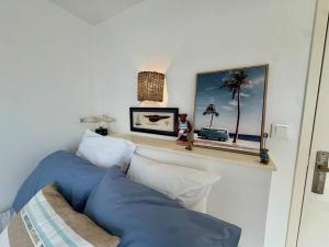 a bedroom with blue and white pillows and a mirror at Entre mer & piscine Maison familiale pour 6 in Brétignolles-sur-Mer +27 photos