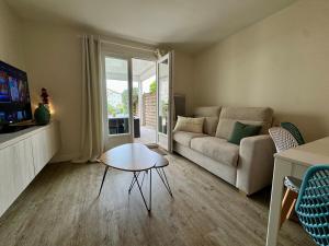 a living room with a couch and a table at Entre mer & piscine Maison familiale pour 6 in Brétignolles-sur-Mer