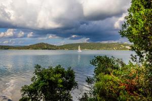 a sailboat on a large lake under a cloudy sky at Sydney Apartment in Bilice