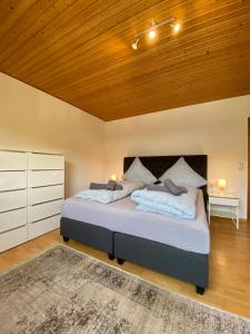 une chambre avec un grand lit avec un plafond en bois dans l'établissement FeWo Sonnenlay - Apartments an der Mosel, à Brauneberg