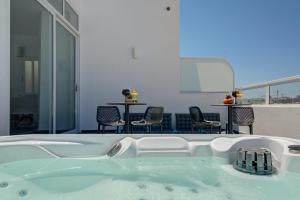a bath tub in a room with a table and chairs at Marina Suites & apartments - Self catering - by Tritoni hotels in Il-Gżira