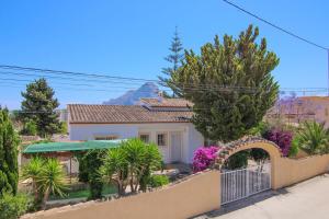 une maison avec une clôture, des arbres et des fleurs dans l'établissement Villa Almendros - Calpe, à Calp