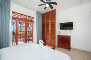 a bedroom with a bed and a flat screen tv at Bahia Azul 2A beachfront, Jaco Beach, 1st floor in Jacó
