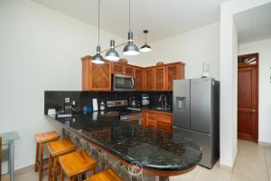 a kitchen with a black counter top and a refrigerator at Bahia Azul 2A beachfront, Jaco Beach, 1st floor in Jacó