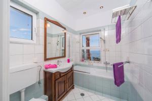 a bathroom with a sink and a tub and a toilet at Villa Vrysoulla by Villa Plus in Nisakion +23 photos