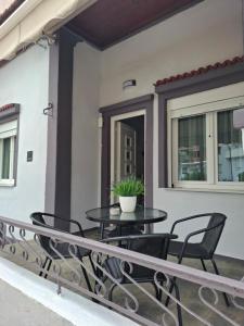 卡瓦拉Serenity的阳台上配有桌椅的露台