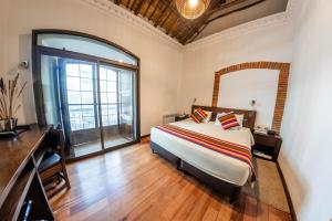 a bedroom with a bed and a large window at La Casona Hotel Boutique in La Paz