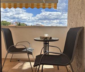 a table and chairs on a balcony with a window at Apartman Karla in Selce