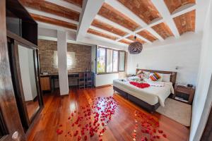 a bedroom with a bed with red petals on the floor at La Casona Hotel Boutique in La Paz