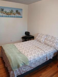 a bedroom with a bed and a picture of palm trees at Home sweet Home West in West Valley City +3 photos