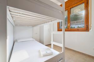 Litera blanca en habitación con ventana en Can Roure piscina y serenidad, en La Pobla de Montornès 40 fotos más