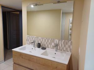 a bathroom with a sink and a large mirror at Le sécadou in Montirat +7 photos