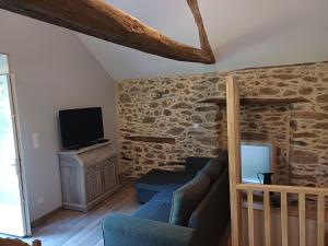 a living room with a couch and a tv at Le sécadou in Montirat