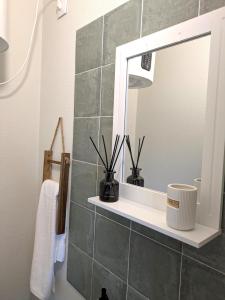 un baño con espejo y lavabo en Monte Gordo Accommodation, en Ribeira Brava