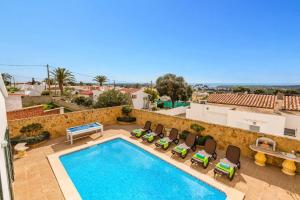 a swimming pool on a patio with chairs and a table at Villa Sidanya by Villa Plus in Cala en Porter
