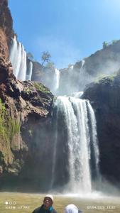 a man standing in front of a waterfall at Maison Touria in Ouzoud