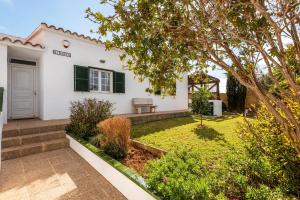 a house with a garden in front of it at Villa Sidanya by Villa Plus in Cala en Porter