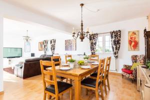 a dining room and living room with a table and chairs at Villa Sidanya by Villa Plus in Cala en Porter