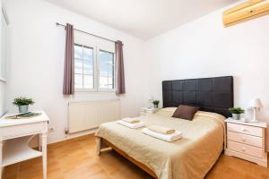 a bedroom with a bed with a black headboard and a desk at Villa Sidanya by Villa Plus in Cala en Porter +17 photos